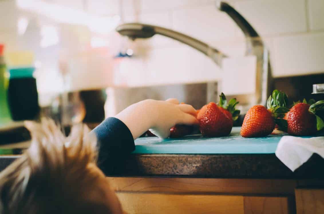 A child working at a child-sized kitchen space in a Montessori environment