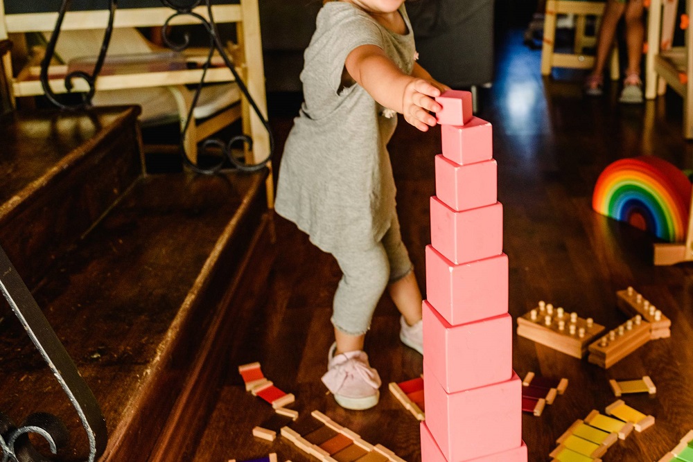 The Montessori Pink Tower, ten wooden cubes stacked from largest to smallest on a floor mat